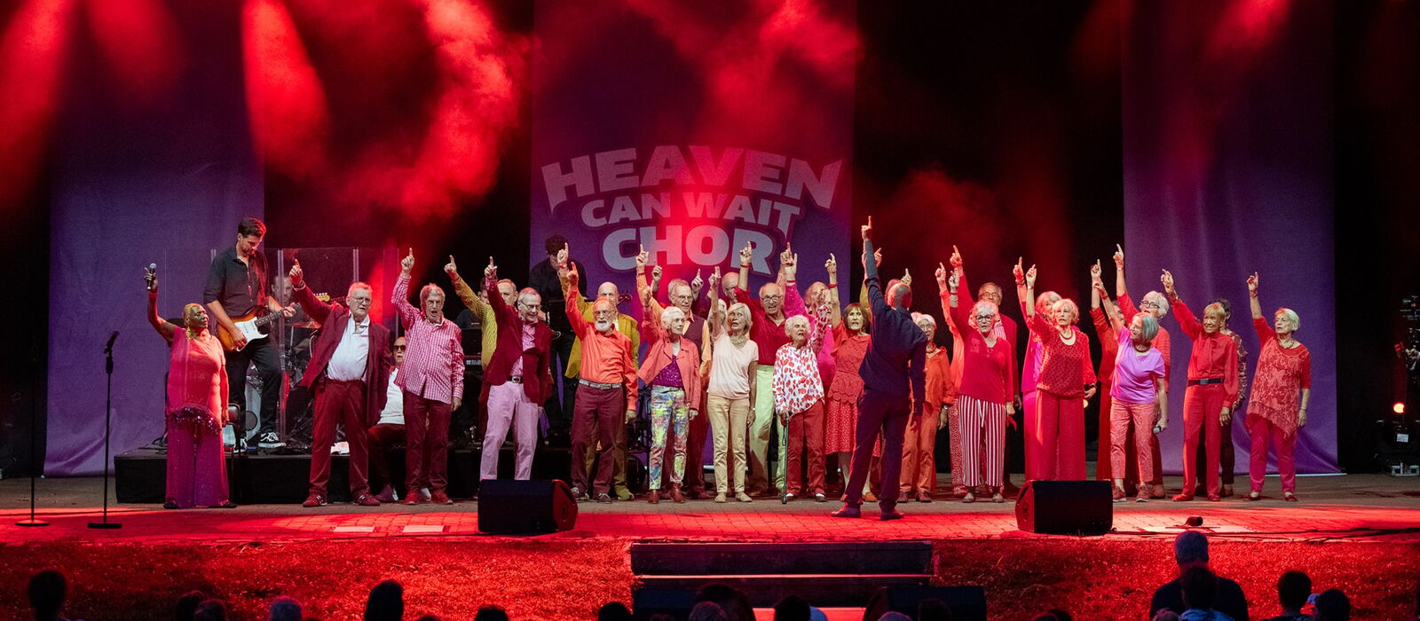 Heaven can Wait Chor auf der Bühne in rotem Scheinwerferlicht