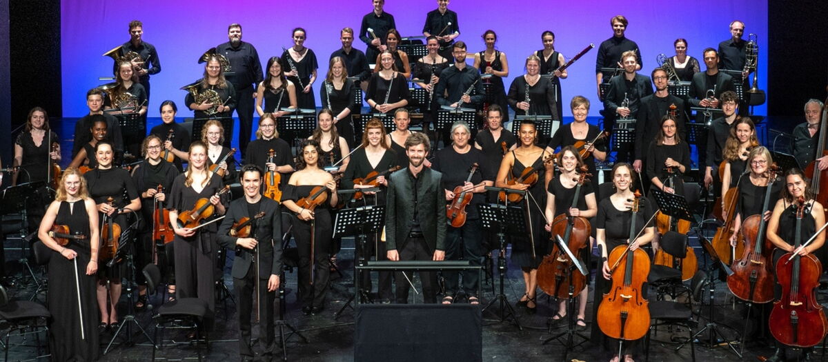 Blick auf das Orchester mit Dirigent auf einer Bühne