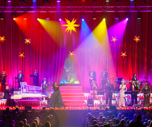 Blick auf die festlich ausgeleuchtete Bühne in der Musik- und Kongresshalle während eines Weihnachtskonzertes von Max and Friends.