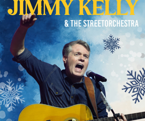 Jimmy Kelly vor einem winterlichen Hintergrund mit gezeichneten Eisblumen, mit einer Gitarre singend.