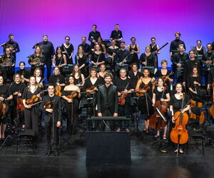 Blick auf das Orchester mit Dirigent auf einer Bühne
