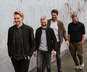 Die Bandmitglieder von Jeden Tag Silvester auf einem Bürgersteig hintereinander laufend.