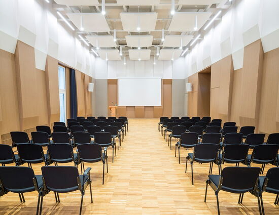 Kleiner Saal mit Reihenbestuhlung und Rednerpult