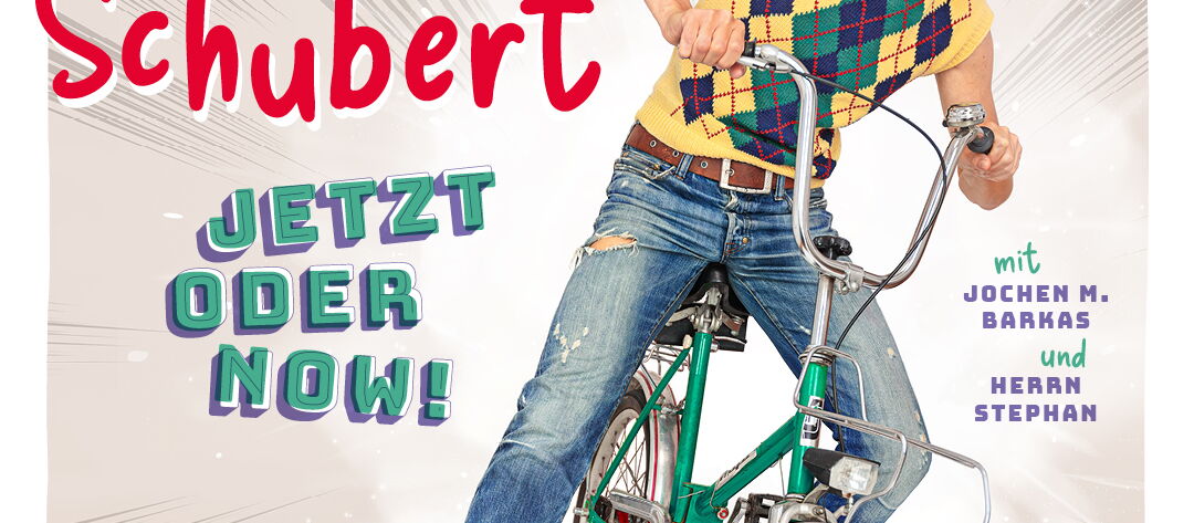 Olaf Schubert sitzt auf einem grünen Fahrrad mit einem überraschten Gesichtsausdruck.