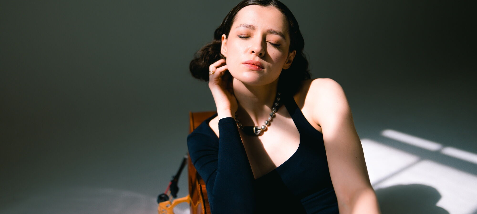 Anastatsia Kobekina, das Gesicht in die Sonne haltend mit geschlossenen Augen.