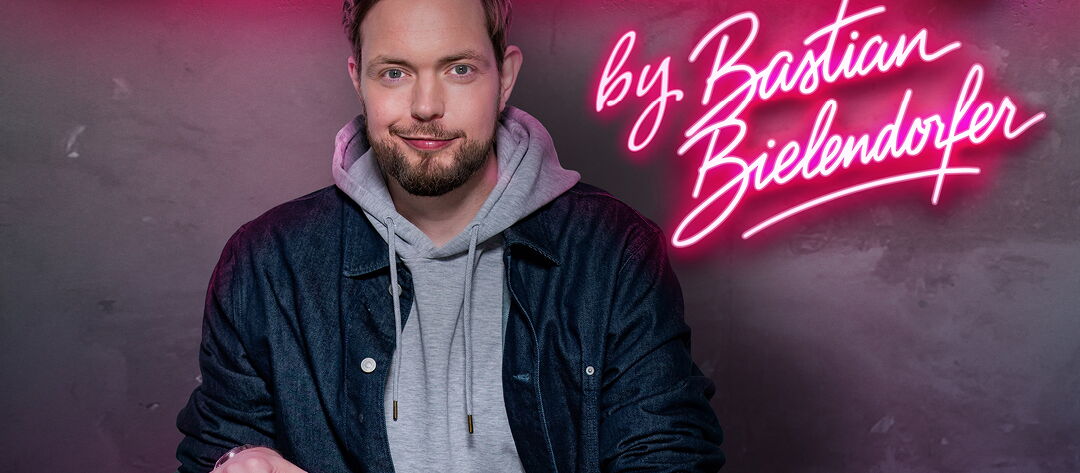 Bastian Bielendorfer sitzend, in die Kamera schauen. Über Bielendorf der Veranstaltungstitel Gamechanger.