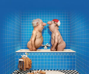 Loriot stehend in der Badewanne. Das Badezimmer blau gefließt.