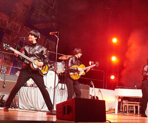 Die  Tribute Band der Beatles auf der Bühne Gitarre spielend