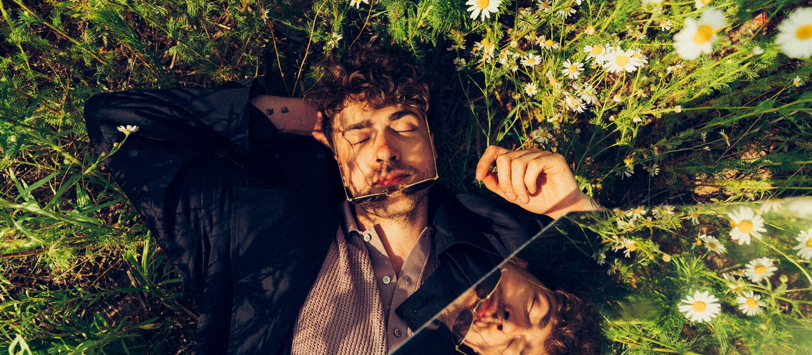 Timon Krause im Gras liegend in der Sonne