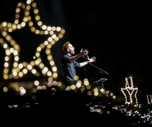 Niels Schroeder singt auf der Bühne umrahmt von Weihnachtsdekoration
