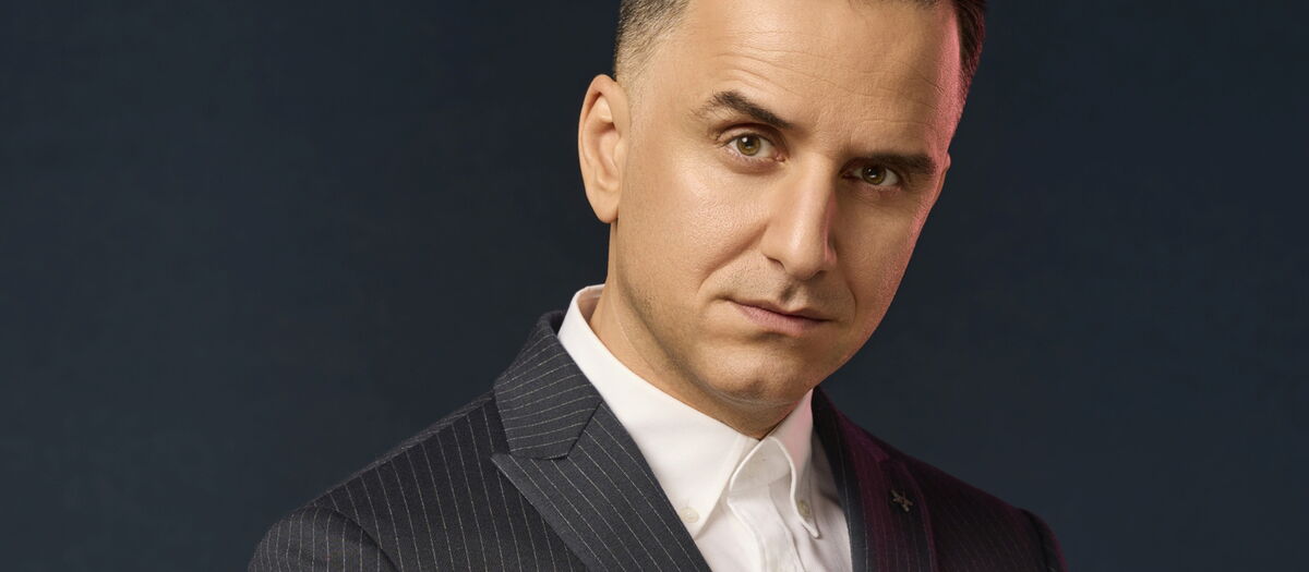 Özcan Cosar Portrait mt schwarzem Anzug und weißem Hemd