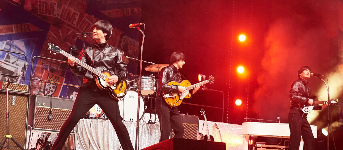 Die  Tribute Band der Beatles auf der Bühne Gitarre spielend