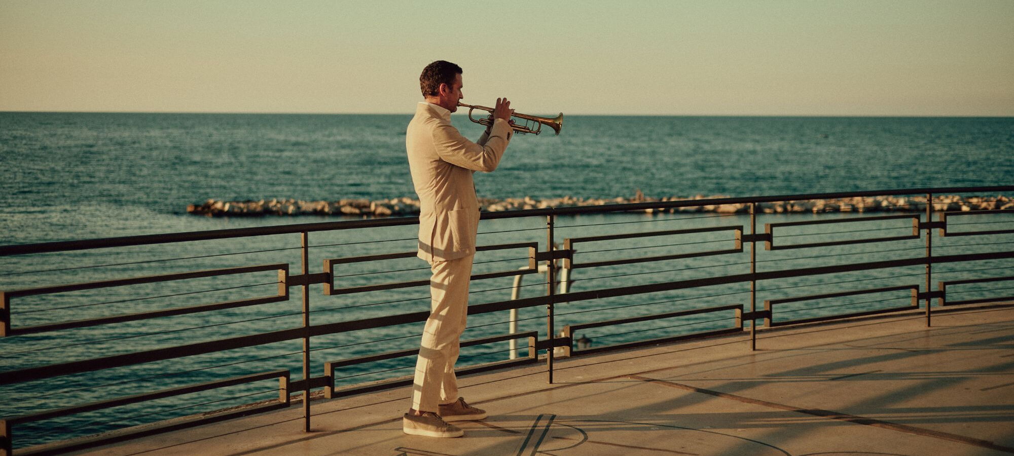 Till Brönner seitlich Trompete spielend am Meer