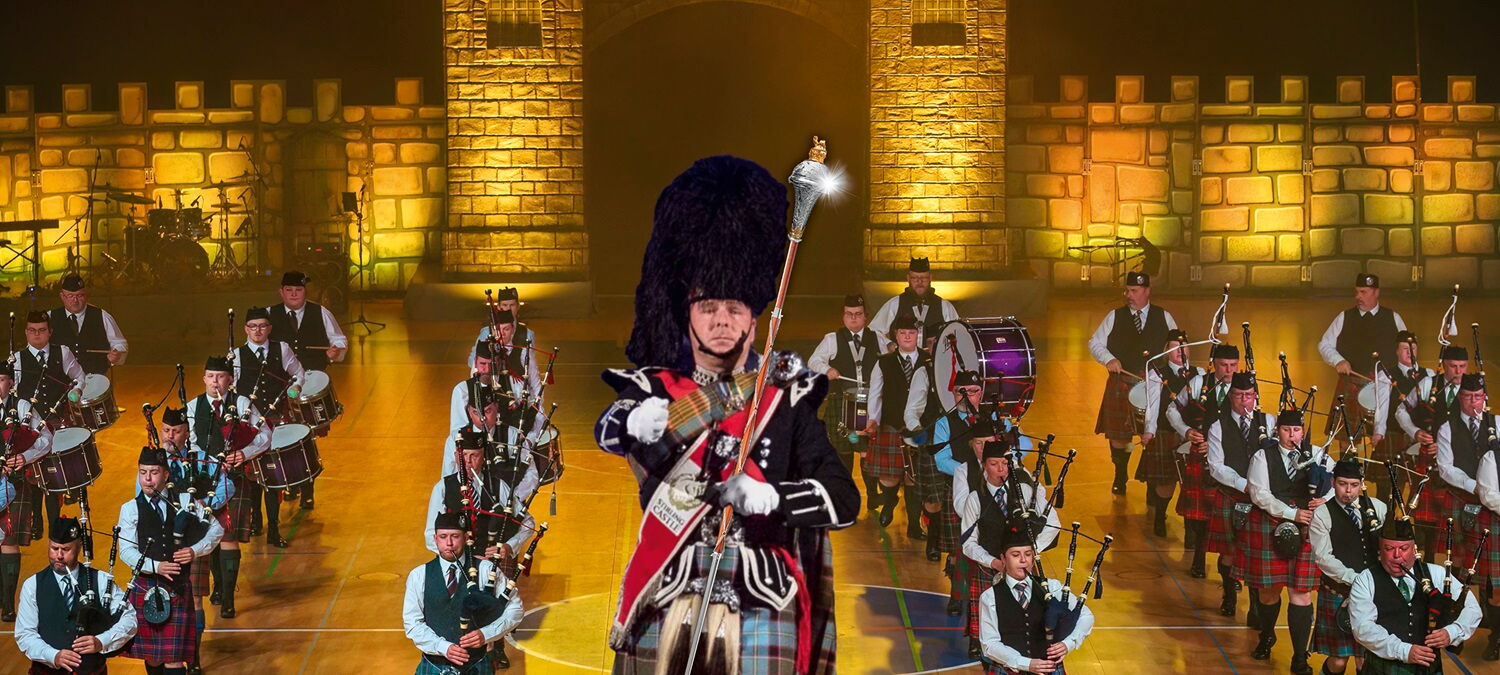 Trommler:innen, Dudelsackspieler:innen auf einer Bühne vor einer Burgmauer