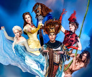 Musical Darsteller:innen in Kostüm und Maske vor blauem Hintergrund.