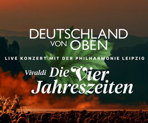 Orchester auf der Bühne vor Publikum spielend. Über dem Publikum ein Eichenblatt, im Vordergrund Titel und Programm des Konzertes.